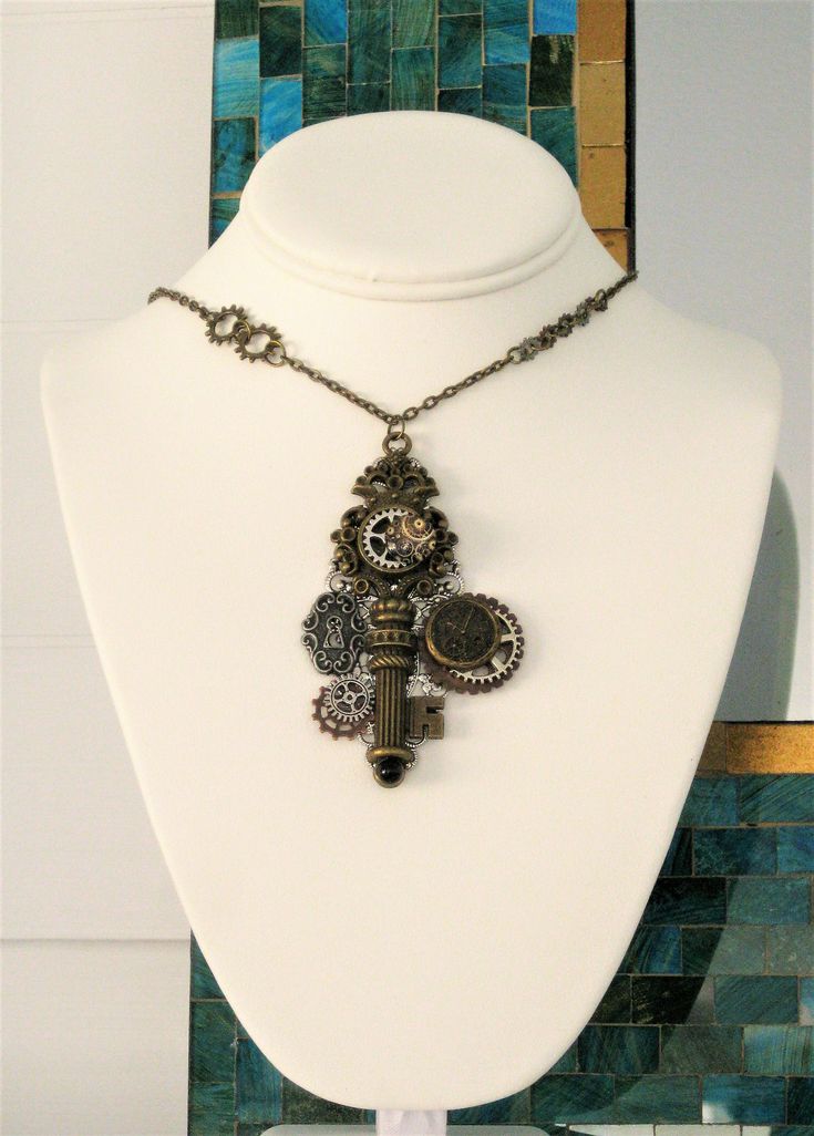 Steampunk Necklace, handmade by Ralston Originals. This Steampunk necklace started with a large antique silver filigree piece, I added many steampunk embellishments, including; a large antique gold skeleton key with a crown top design, an antique gold metal clock face charm, antique silver metal lock charm, a small glass cabochon with steampunk gear design, and silver, and copper metal steampunk gears. The necklace chain is antique gold metal, with steampunk gears. This Steampunk necklace is 16 Steampunk Bronze Pendant Necklace, Bronze Steampunk Metal Necklace, Steampunk Jewelry With Vintage Charm, Steampunk Antique Gold Metal Necklaces, Steampunk Silver Brass Necklaces, Steampunk Silver-color Brass Necklaces, Steampunk Metal Jewelry Vintage Collection, Silver Steampunk Brass Necklaces, Steampunk Metal Necklaces With Antique Finish