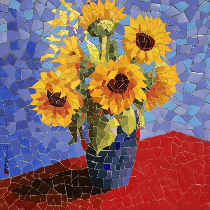 a vase filled with yellow sunflowers on top of a red table covered in mosaic tiles