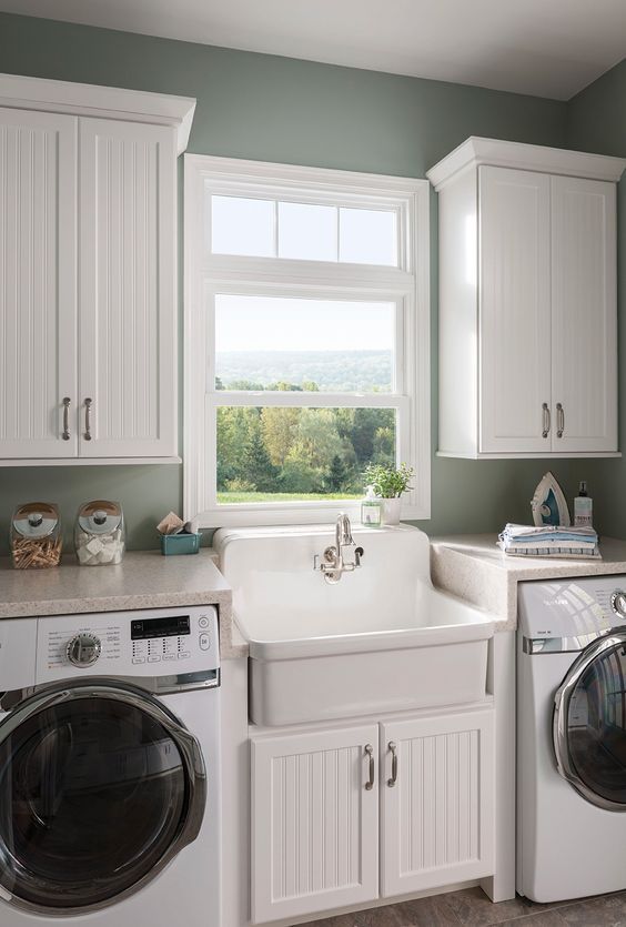 a washer and dryer in a small room with green paint on the walls