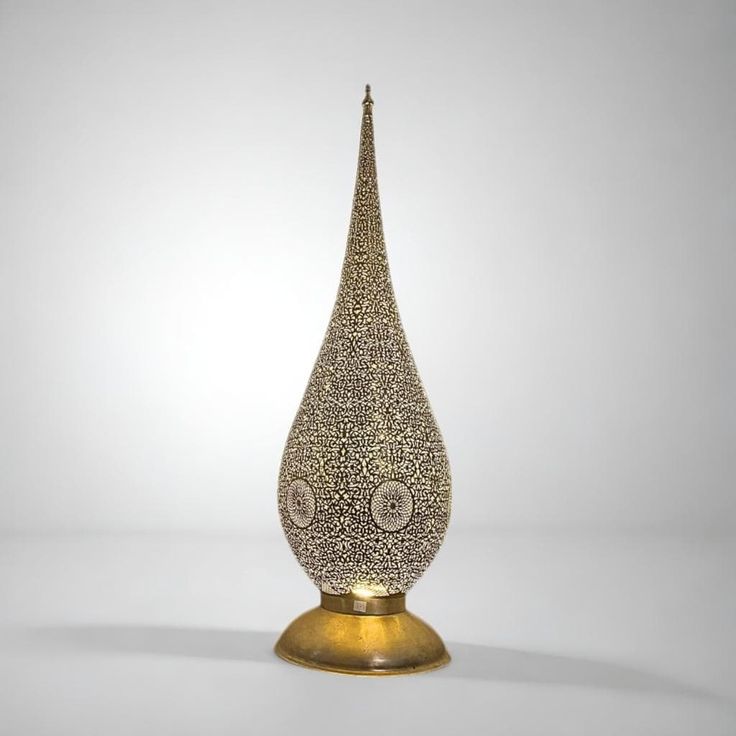 a gold and white vase sitting on top of a table