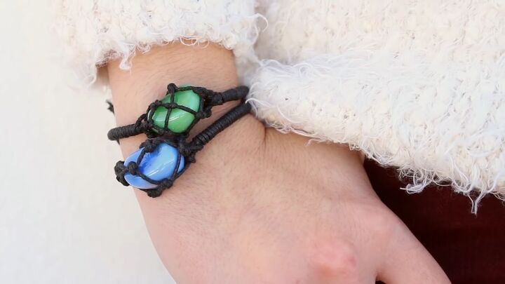 a woman's hand with a bracelet made out of glass beads and black cords