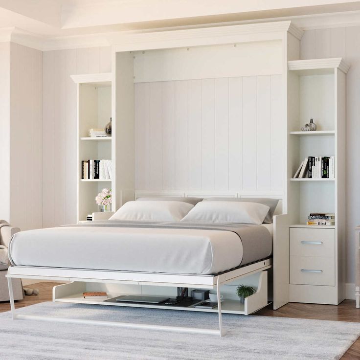 a white bed sitting in a bedroom next to a book shelf and dresser with drawers