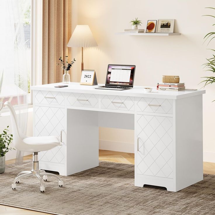 a white desk with a laptop on it in front of a window and potted plant