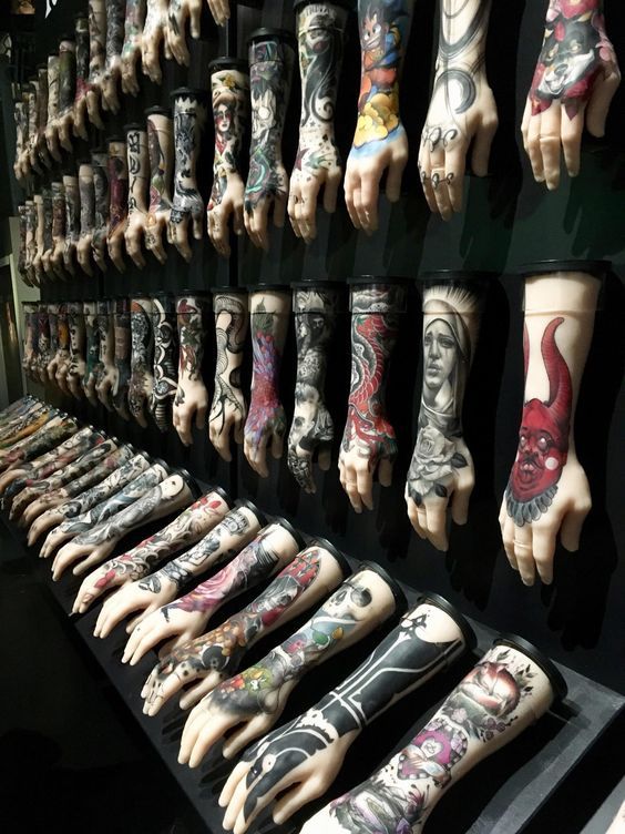 many different tattoos are on display in a store window with hands and feet painted all over them