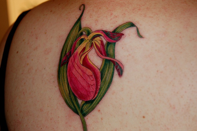 a woman's back with a flower tattoo on it