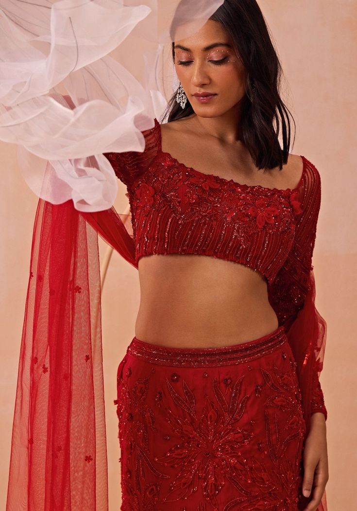 Elevate your festive wardrobe with the Red Embroidered Fishcut Lehenga Set, crafted from luxurious Satin Georgette. The stunning red lehenga features a graceful fishcut silhouette adorned with statement floral motifs that exude elegance and sophistication. The accompanying 3D floral blouse is a work of art, with intricate embroidery that adds depth and texture, making it a standout piece. Completing the ensemble is a beautifully draped dupatta, adding a touch of traditional charm. Perfect for a bride or bride-to-be on your special day. Composition : Lehenga, Blouse & Dupatta : Satin Georgette Care: Dry Clean Only and Vacuum Storage This product can be customized for sleeves, length and colour Delivery : 4-6 weeks as the product is hand crafted. Check Size Guide or choose MySize for free cu Red Anarkali Set With Floral Embroidery For Reception, Red Anarkali Lehenga With Floral Embroidery, Semi-stitched Red Sharara With Floral Embroidery, Red Semi-stitched Sharara With Floral Embroidery, Red Floral Embroidered Semi-stitched Sharara, Party Wear Floral Embroidered Floor-length Lehenga, Party Wear Floor-length Lehenga With Floral Embroidery, Red Sharara With Floral Embroidery For Wedding, Red Floor-length Sharara With Unstitched Blouse