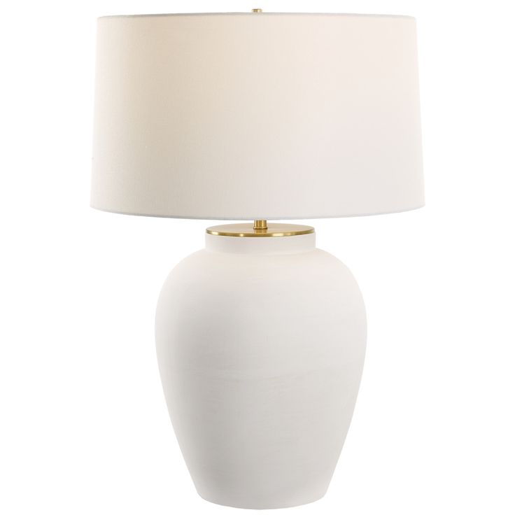 a white table lamp with a beige shade on the bottom and gold trim around the base