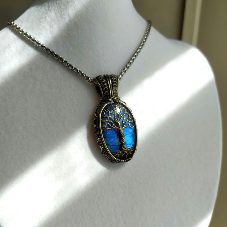 Discover the beauty of our unique Tree of Life pendant, meticulously handcrafted with care and attention to detail. This enchanting necklace features a stunning blue Labradorite stone, elegantly wrapped in German silver wire with a brass Tree of Life design. **What Makes This Pendant Special - **Handmade Craftsmanship Each pendant is entirely handcrafted, ensuring a one-of-a-kind piece. - **Spiritual Symbolism The Tree of Life design symbolizes growth, strength, and connection, making it a meaningful gift. - **Quality Materials Made with German silver wire and brass, paired with a striking blue Labradorite stone known for its mystical and protective qualities. - **Versatile Style The pendant comes with a steel chain, making it a versatile addition to any jewelry collection. **Product Detai Unique Sapphire Necklace For Gift, Unique Sapphire Necklace As Gift, Nickel Free Labradorite Jewelry As Gift, Nickel Free Labradorite Jewelry For Gift, Nickel-free Labradorite Jewelry As Gift, Blue Engraved Necklace For Keepsake, Blue Engraved Necklace For Gift, Labradorite Blue Necklace As Gift, Blue Spiritual Jewelry For Gifts