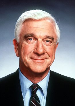 an older man in a suit and tie smiling at the camera with his eyes wide open