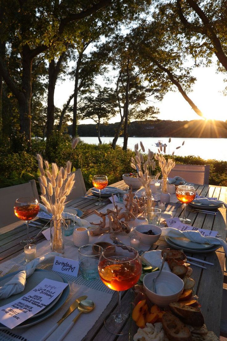 an outdoor dining table set with plates and utensils