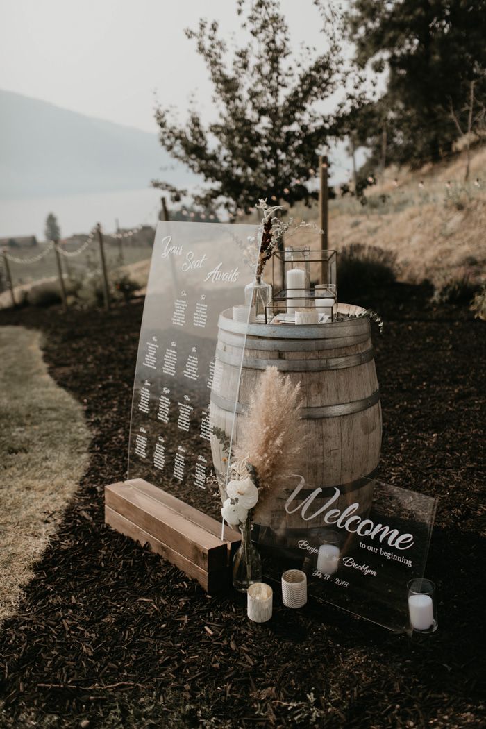 a wooden barrel with candles on it next to a welcome sign