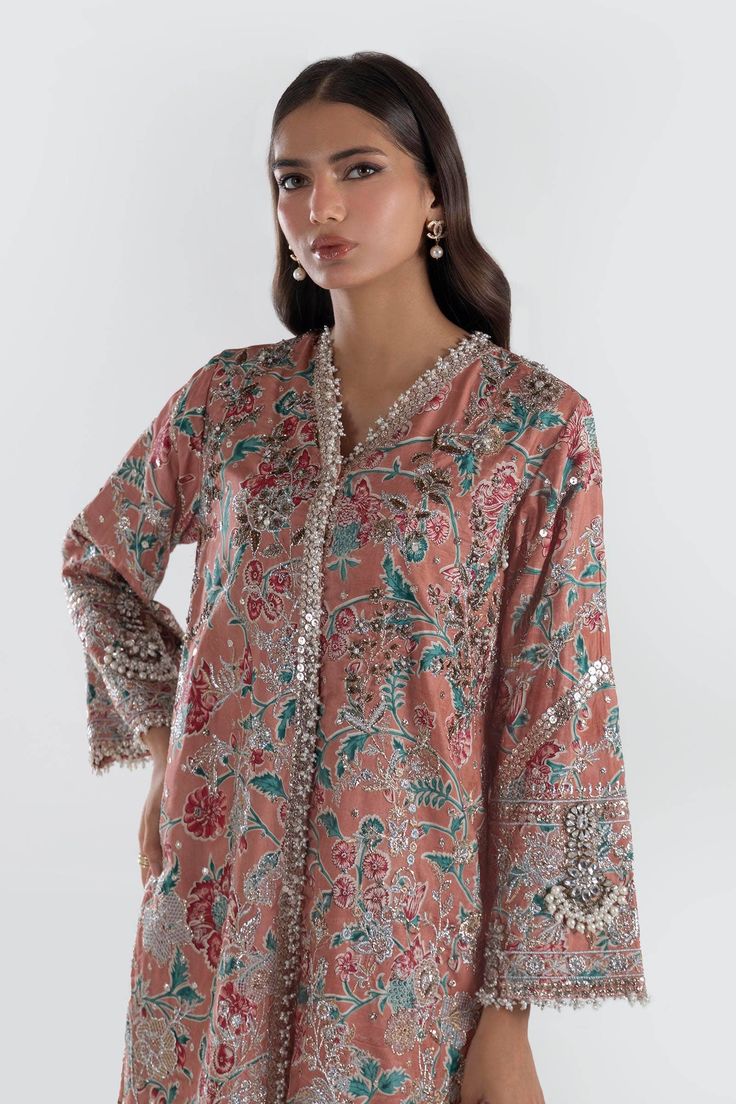 Royal Chauntae Pink Luxury Pret Short Shirt Style Pakistani Salwar Kameez is Silhouette that seamlessly transitions you into the celebratory season. Detailed Description: SKU: PB704 Detailing: Embroidery, Threads, Motifs, Patchwork Color: Pink Fabric: Chiffon, Raw Silk Design: Fully Embellished Dress with Embroidery Event: Bridal wear, Wedding V-neck Traditional Wear For Eid, Festive V-neck Kurta For Party, Festive Semi-stitched Long Sleeve Kaftan, Festive Long Sleeve Semi-stitched Kaftan, Naqshi Saree For Party, Semi-stitched Long Sleeve Kaftan With Dabka Work, Long Sleeve Semi-stitched Kaftan With Dabka Work, Semi-stitched Long Sleeve Kaftan For Festive Occasions, Unstitched V-neck Festive Kurta