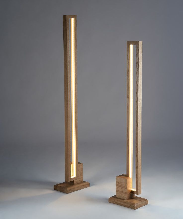 two wooden poles with lights on them against a gray background