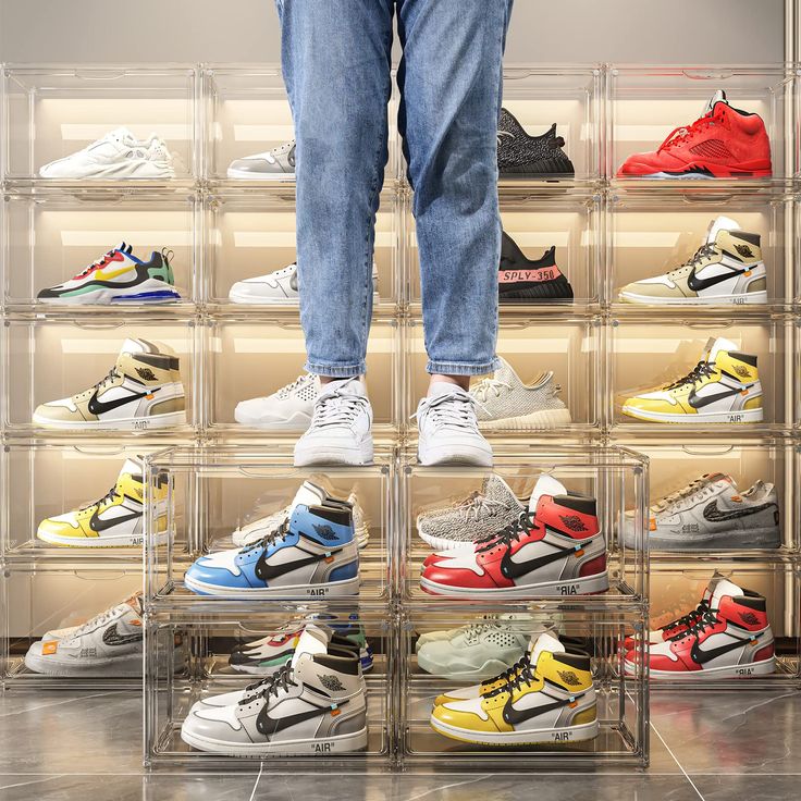 a person standing on top of a clear shelf filled with different colored nike sneakers and shoes