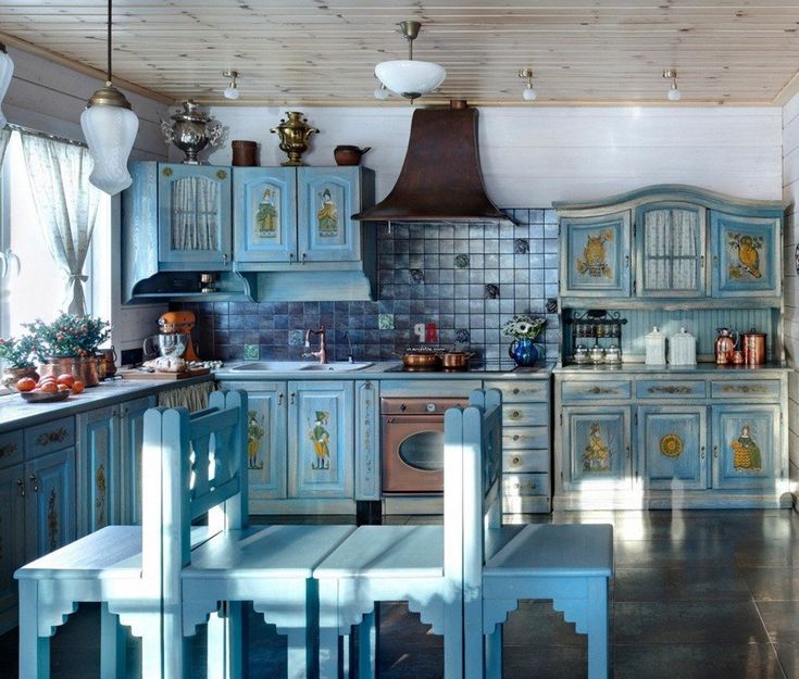 a kitchen with blue painted cabinets and wooden flooring, along with an oven in the center