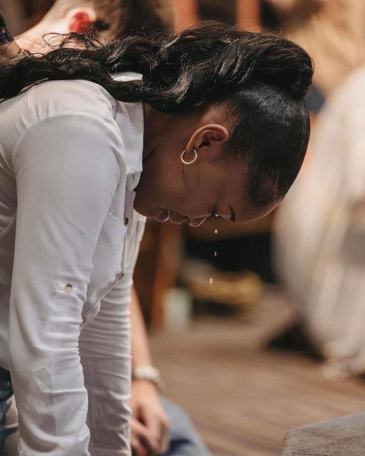 a woman sitting on the ground with her head down