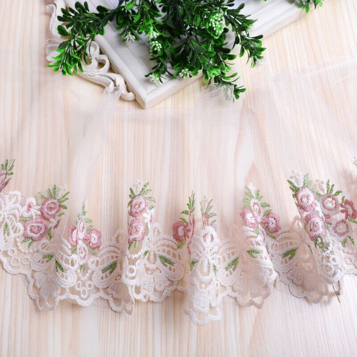 pink roses and green leaves are on the sheer fabric, along with lace trims