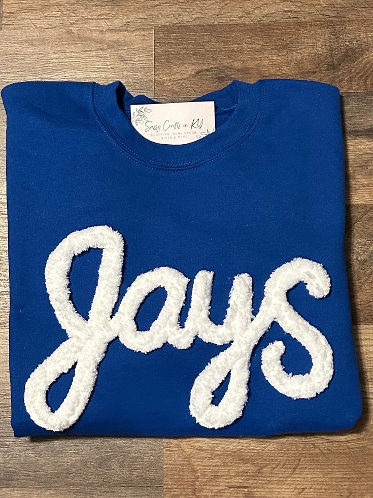 Show your school spirit in this cute sweatshirt. Comfort, casual and loose fitting, made on 50/50 cotton/poly blend shirts.  Embroidered chenille yarn, Jays sweatshirt.   Please message us if you have a custom color request and we will create a separate listing for custom requests.  You can follow us at the below link for chances to win giveaways and to see all of our latest creations.  https://www.facebook.com/groups/710060383256657/?ref=share&mibextid=S66gvF Pre-shrunk Crew Neck Sweatshirt For School Spirit, Varsity Sweatshirt With Letter Embroidery For College, Sporty Tops With Embroidered Logo In French Terry, Team Spirit Fleece Crew Top, Collegiate Crew Fleece Sweatshirt, Collegiate Fleece Crew Sweatshirt, Team-colored Long Sleeve Sweatshirt For School Spirit, Team-colored Long Sleeve School Spirit Sweatshirt, Blue Crew Sweatshirt For Game Day