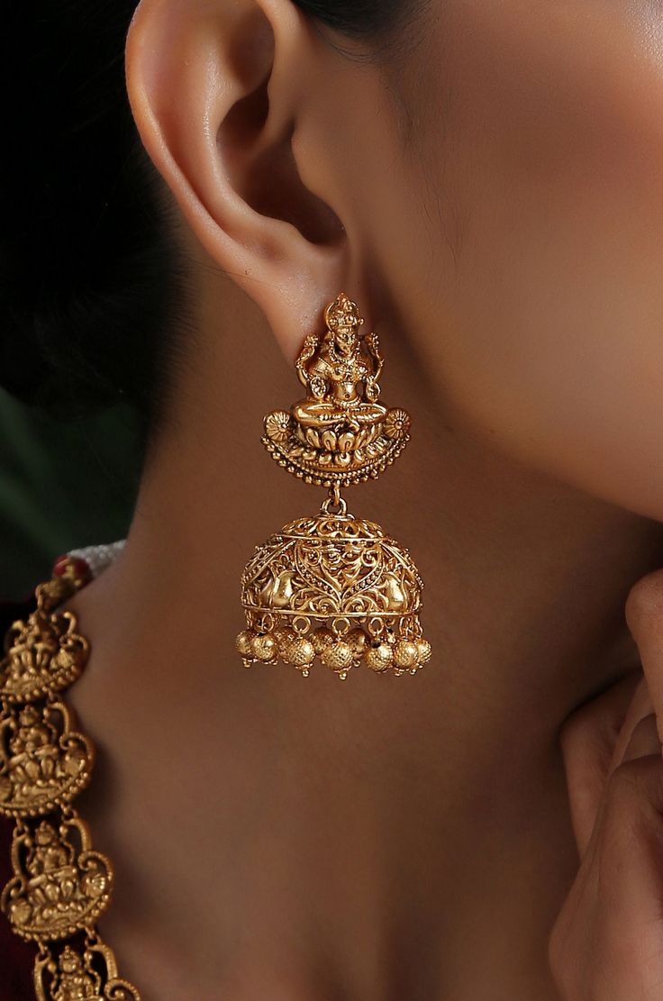 This opulent intricacy worked in geru gold plated silver alloy has its charm in its regal detailing. The monotonicity of gold is eased by adding the pretty pearls accentuating the charm of this temple work beauty. Necklace Closure - Adjustable Dori Earrings Closure - Push Back Style Tip - Style this with classic banarasi sarees, lehengas or indo western wear dresses. A perfect match with almost any traditional classic. This one comes straight off a nani inspired jewelery wardrobe and offers hint Elegant Antique Gold Chandbali Temple Necklace, Gold Hallmarked Chandbali Temple Necklace, Hallmarked Gold Plated Temple Necklace For Diwali, Elegant Heavy Antique Gold Jewelry, Ornate Antique Gold Festive Jewelry, Festive Ornate Antique Gold Jewelry, Gold-plated Chandbali Temple Necklace In Yellow Gold, Gold Plated Temple Jewelry Necklaces With Latkans, Antique Gold Temple Necklace With Intricate Design As Gift