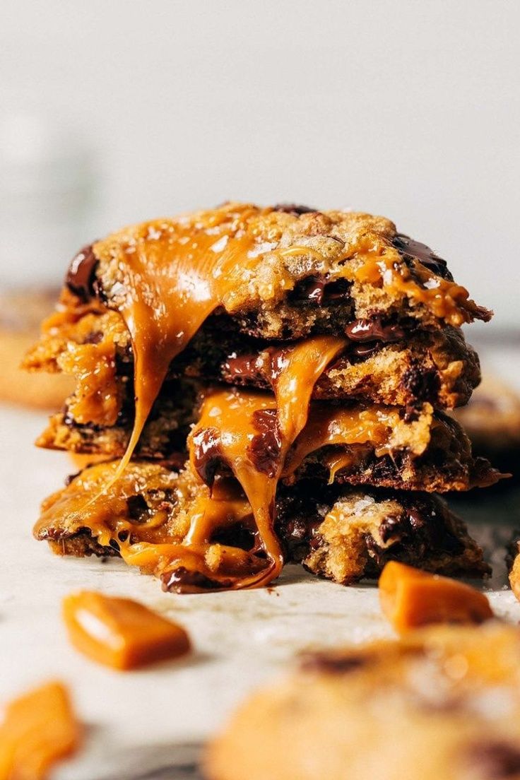 chocolate chip cookies stacked on top of each other with caramel sauce drizzled over them