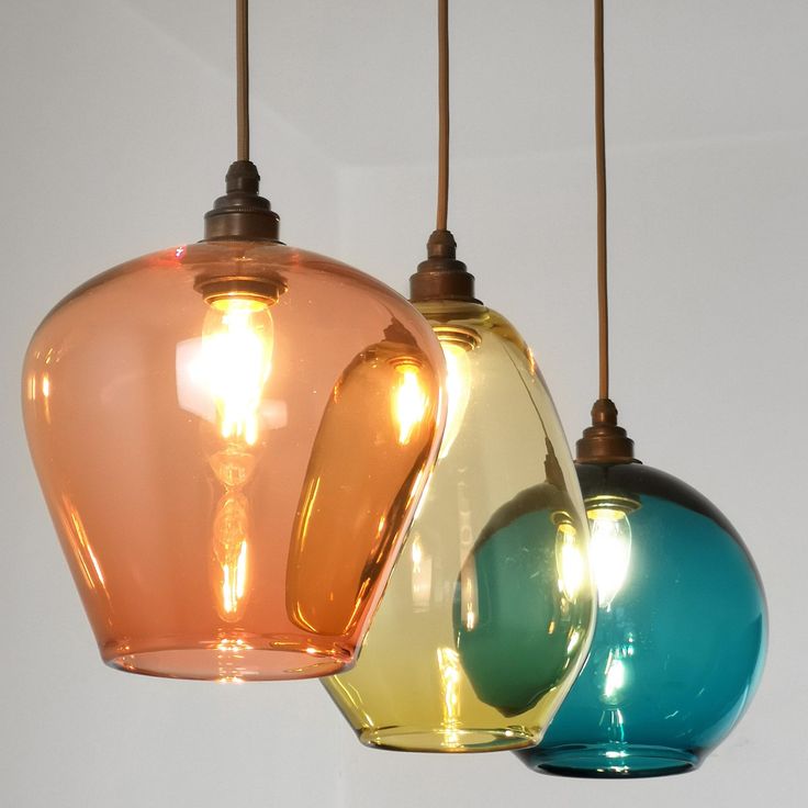 three different colored glass lights hanging from a ceiling