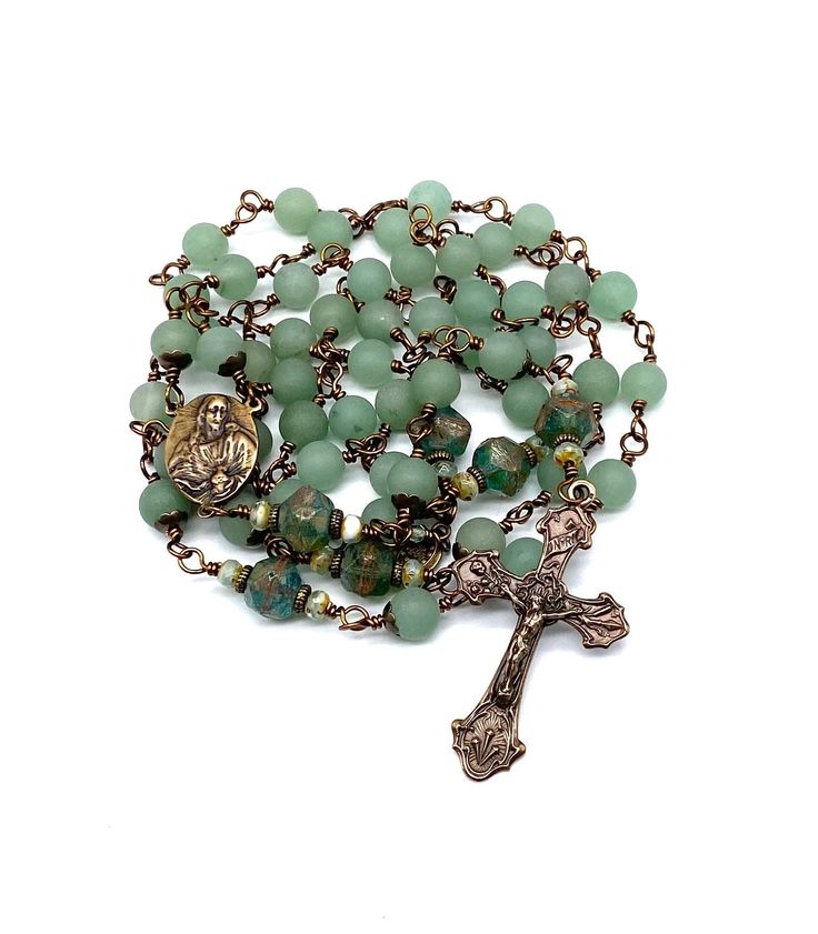 a rosary with green beads and a medal on it's end is shown in front of a white background