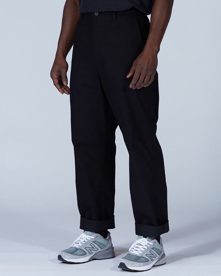 The Takibi Chino Pants are casual fire-resistant pants. The pants are made of cotton and modacrylic. The Takibi Chino Pants feature a button closure, dual side pockets, a coin pocket, and dual back pockets. The Takibi Chino Pants are designed to fit loose in the leg, with the hem hitting below the ankle. We recommend taking your normal size for a standard fit. The model stands 6' and wears size L. Cotton Casual Pants, Fire Grill, Snow Peak, Chino Pants, Cotton Pants, Outdoor Accessories, Chinos Pants, Cut And Style, Black Pants