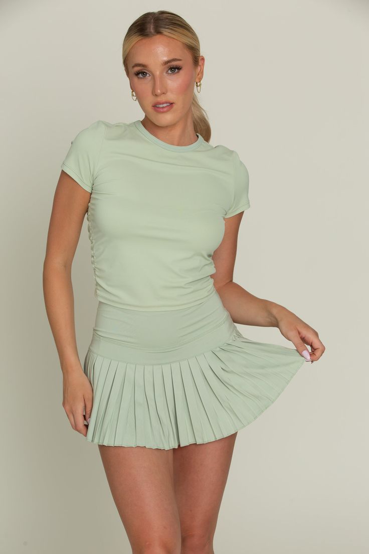 Our Pastel Green Pleated Tennis Skirt is the best everyday piece to add to your wardrobe because of its versatility & functionality. The skirt features built-in spandex shorts that include a comfortable fit and side pockets for storage. This exclusively designed Gold Hinge skirt is made of quick dry material and can take on any activity such as golf, tennis, running and more. Casual Fitted Skort With Elastic Waistband, Fitted Tennis Skirt With Pockets, Versatile Fitted Tennis Skirt With Built-in Shorts, Sporty Fitted Tennis Skirt With Pockets, Fitted Elastane Skort With Built-in Shorts, Casual Fitted Swim Skirt For Sports, Fitted Swim Skirt With Pockets For Spring, Fitted Athleisure Swim Skirt, Fitted Versatile Skort For Workout