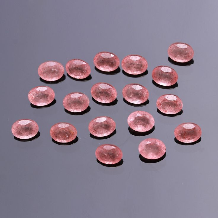 many pink diamonds are arranged on a gray surface