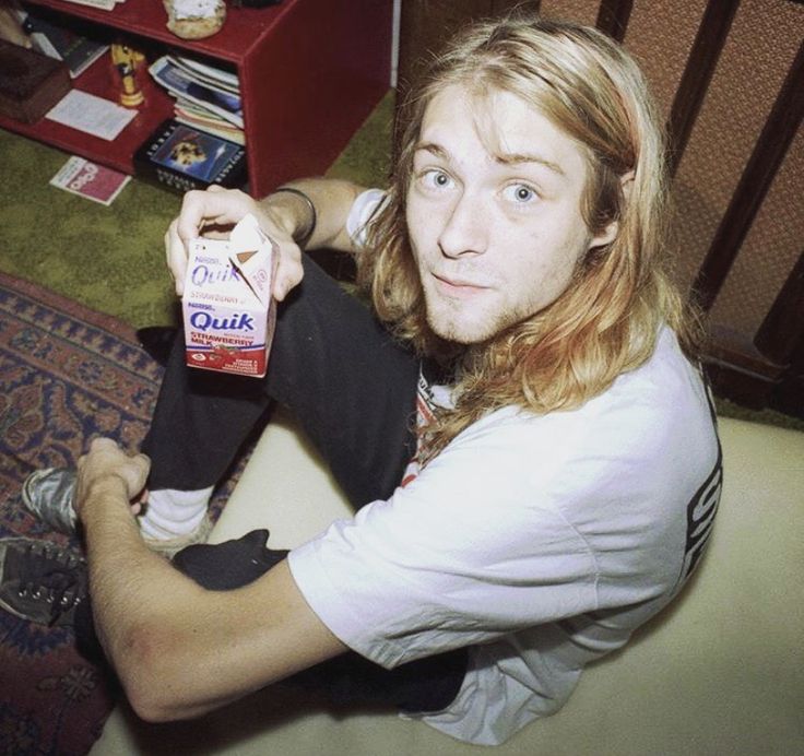 a man sitting on the floor holding onto a bottle