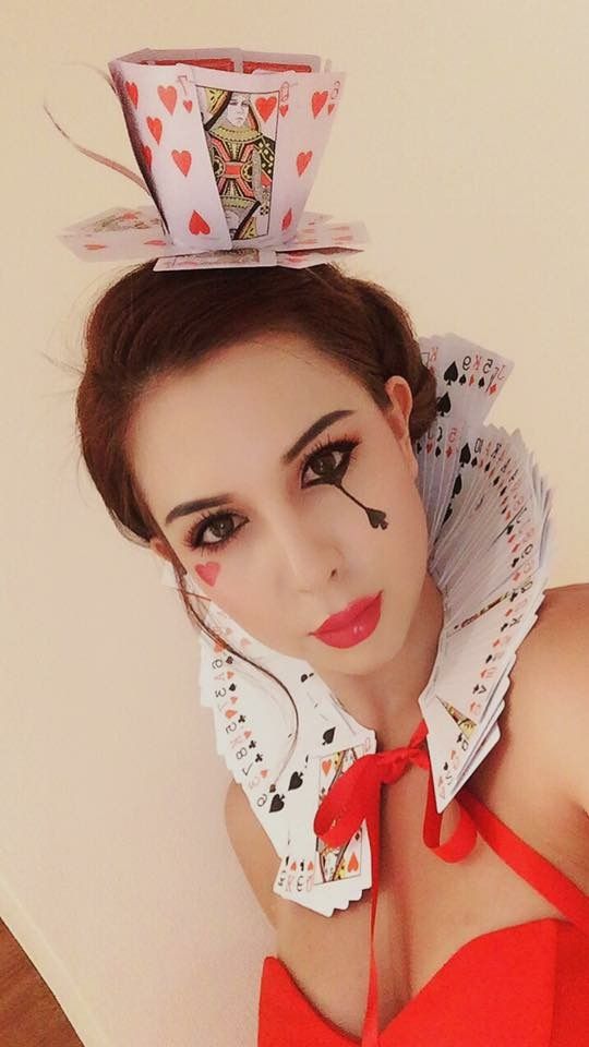 a woman in a red dress with a paper hat on her head and an origami fan above her head