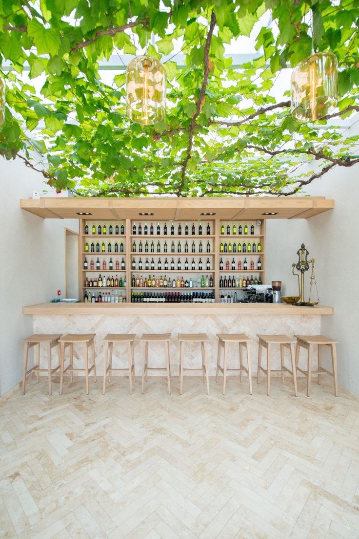 an indoor bar with several stools under a tree