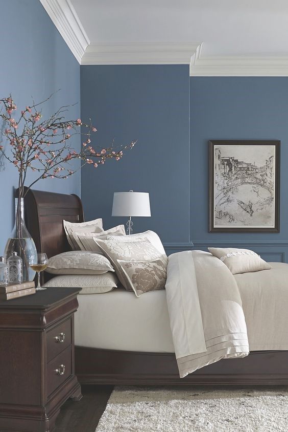 a bedroom with blue walls and white bedding