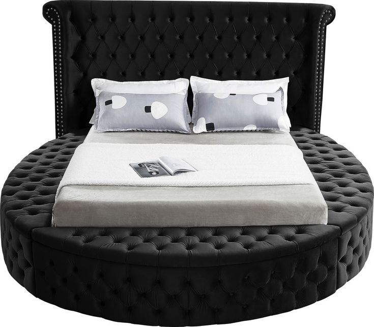 a round bed with two pillows on top of the headboard and foot board is shown