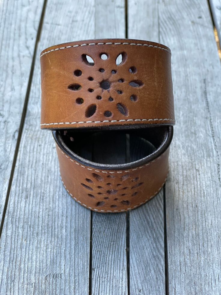 This is a hand tooled leather cuff bracelet made from Vegetable tanned leather, oiled, stained, hand stamped, painted and sealed with a protective acrylic finish. It is approximately 1" wide x 9" total length (8" from snap to snap) which should fit an average size wrist. My wrist is 6 1/4" and it fits me a little loose. These are made to order so if you feel you need a bigger size please send me a message to discuss. Distressed Brown Leather Bracelets As Gift, Vintage Hand-tooled Leather Cuff Bracelet, Rustic Leather Cuff Bracelet With Leather Strap, Rustic Leather Cuff Bracelet, Vintage Leather Festival Bracelets, Rustic Brown Leather Strap Cuff Bracelet, Distressed Brown Leather Cuff Bracelet, Unique Leather Cuff Bracelet With Strap, Hand Tooled Leather Bracelets For Festivals