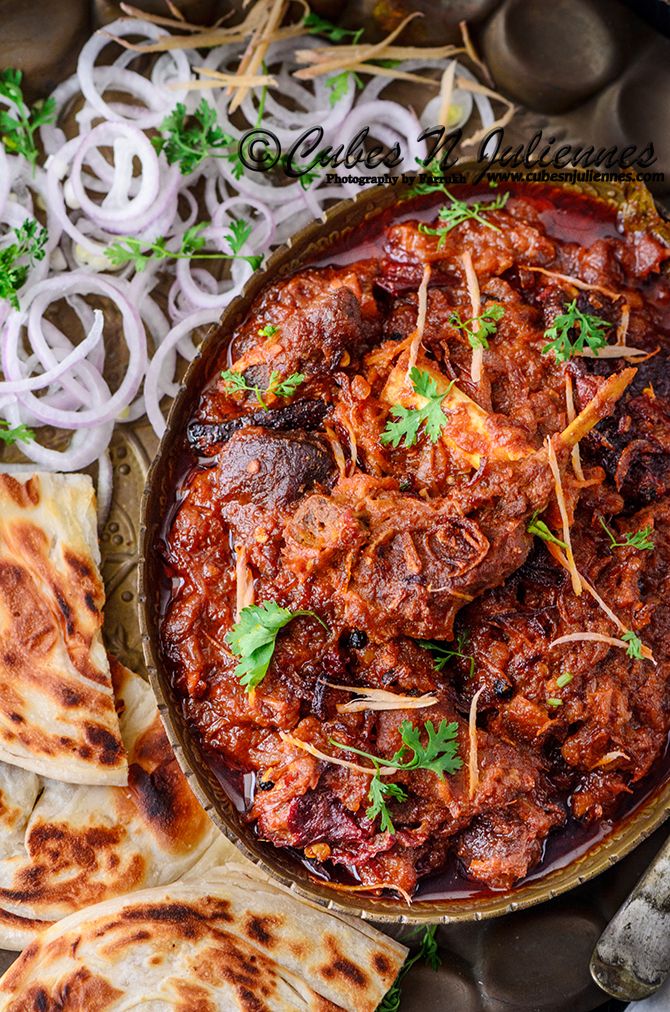 a bowl filled with meat and veggies next to pita bread