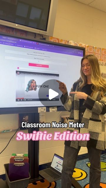 a woman standing in front of a flat screen tv with the words classroom noise meter on it