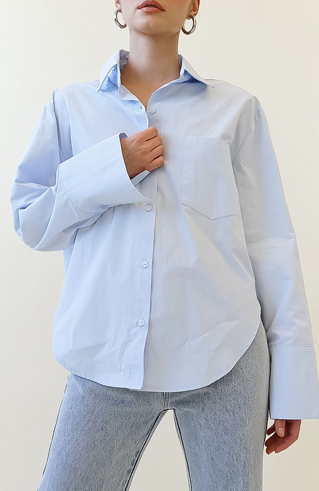 COLOR: POWDER BLUE DETAILS Features a oversized fit, button down front closure, collared neckline, rounded high-low hem, sleeve cuffs with button closure and front pocket design non-stretch 100% Cotton Please refer to the care label for garment care instructions SIZE & FIT: runs TTS, model wears size S/M MODEL INFO: HEIGHT 5’6, WAIST 25in, BUST 32in Oversized Blue Button-up Shirt, Blue Long Sleeve Shirt With Cuffed Sleeves, Blue Shirt With Roll-up Sleeves For Everyday, Blue Shirt With Button Cuffs And Shirttail Hem, Oversized Light Blue Collared Shirt, Blue Shirt With Roll-up Sleeves, Trendy Blue Shirt With Button Cuffs, Blue Blouse With Button Cuffs And Shirttail Hem, Blue Everyday Shirt With Button Cuffs