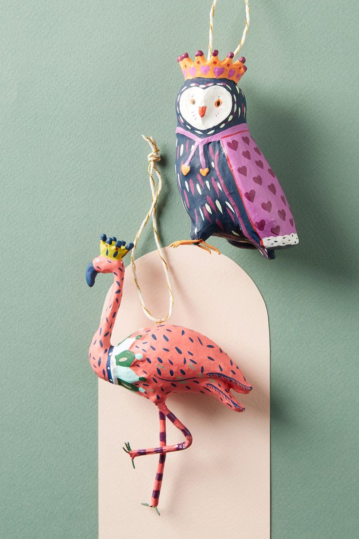 two colorful birds are hanging on the wall