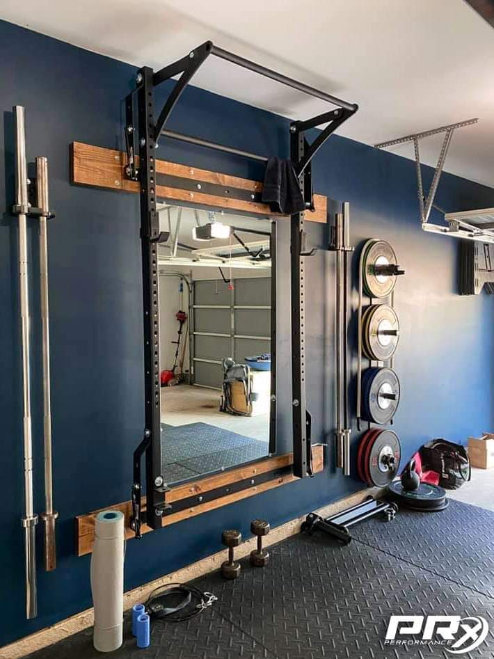 a gym room with mirrors and equipment on the wall