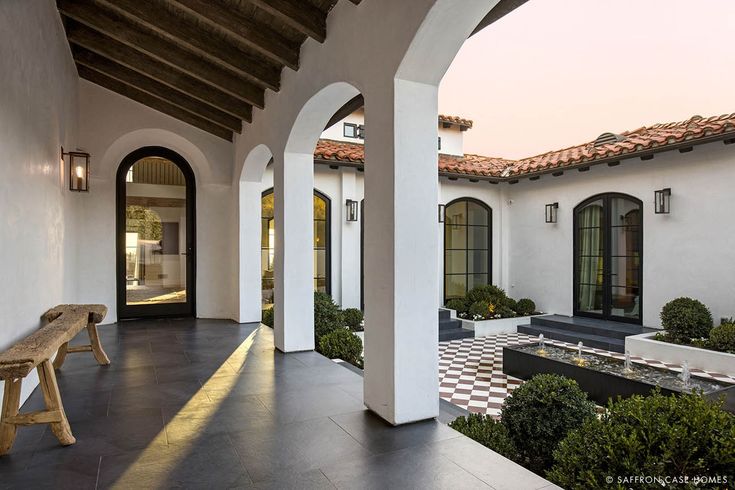 an outdoor courtyard with benches and potted plants