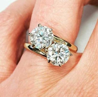 a woman's hand with two engagement rings on it