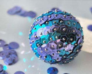 a blue and purple ball with silver rivets on it's surface next to confetti