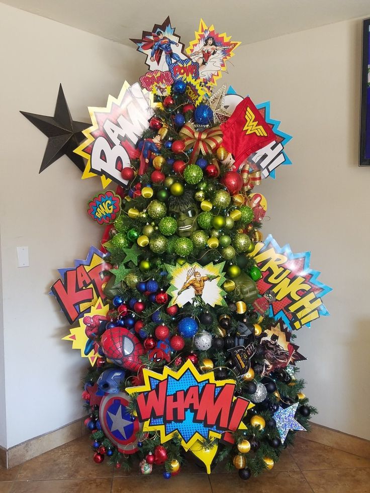 a decorated christmas tree in the corner of a room with comic themed decorations on it