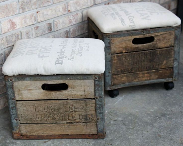 two wooden boxes sitting next to each other near a brick wall with writing on them