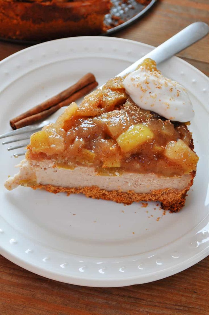 a piece of pie on a white plate with a fork and cinnamon stick next to it