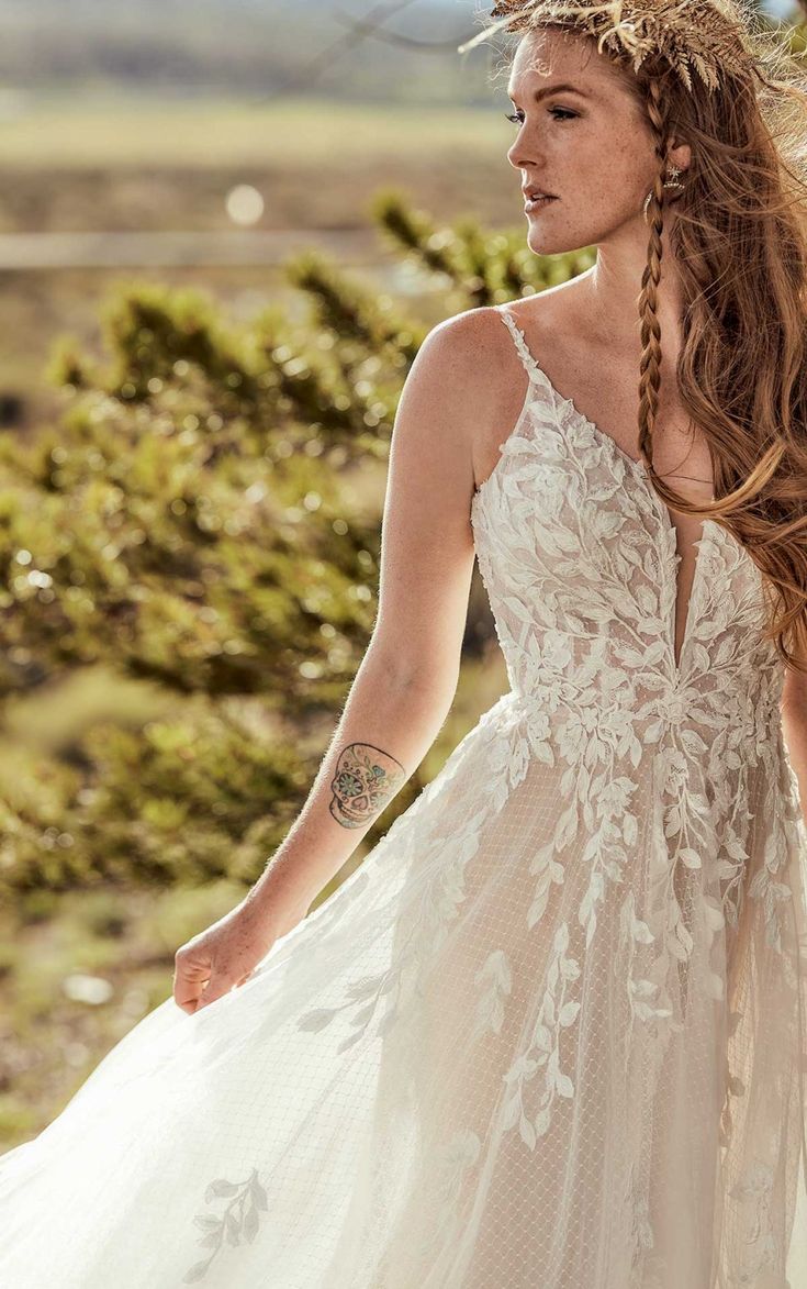 a woman with long hair wearing a white wedding dress and braids in her hair