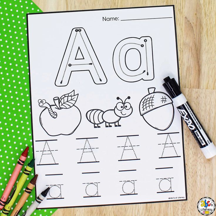 an alphabet worksheet with crayons and markers on the table next to it