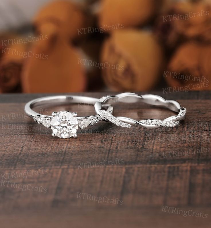 two wedding rings sitting on top of a wooden table