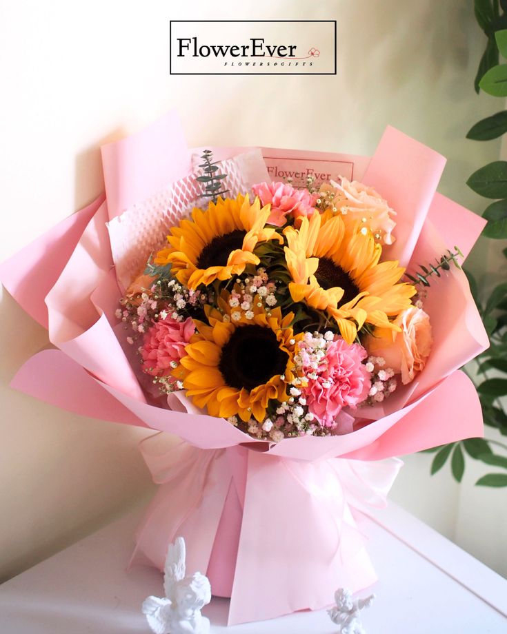 a bouquet of sunflowers and baby's breath in a pink wrapper